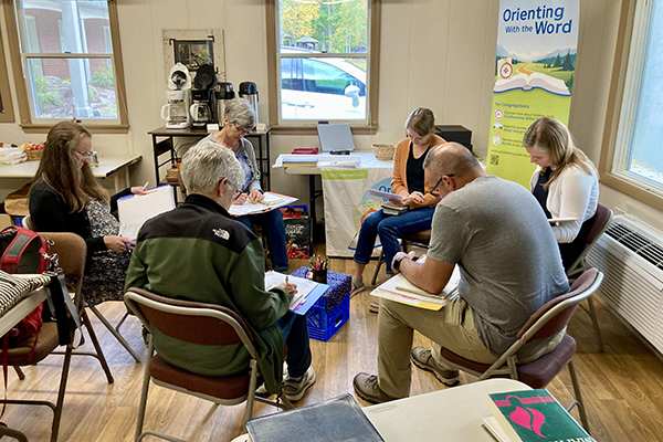 Participants in a Bible study group through the Orienting With the Word program of Anabaptist Mennonite Biblical Seminary’s Faith Formation Collaborative meet during a retreat and training seminar in September 2025 at Laurelville Retreat Center, Mount Pleasant, Pennsylvania, to practice studying  the text. (Credit: Margaret Miller/AMBS)